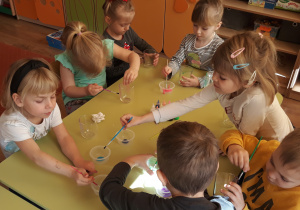 Dzieci ozdabiają szklane pojemniki